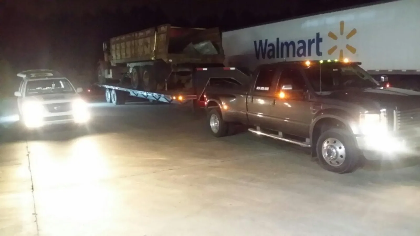Roadside Hawks working a vehicle at night, lit by headlights and work lamps.