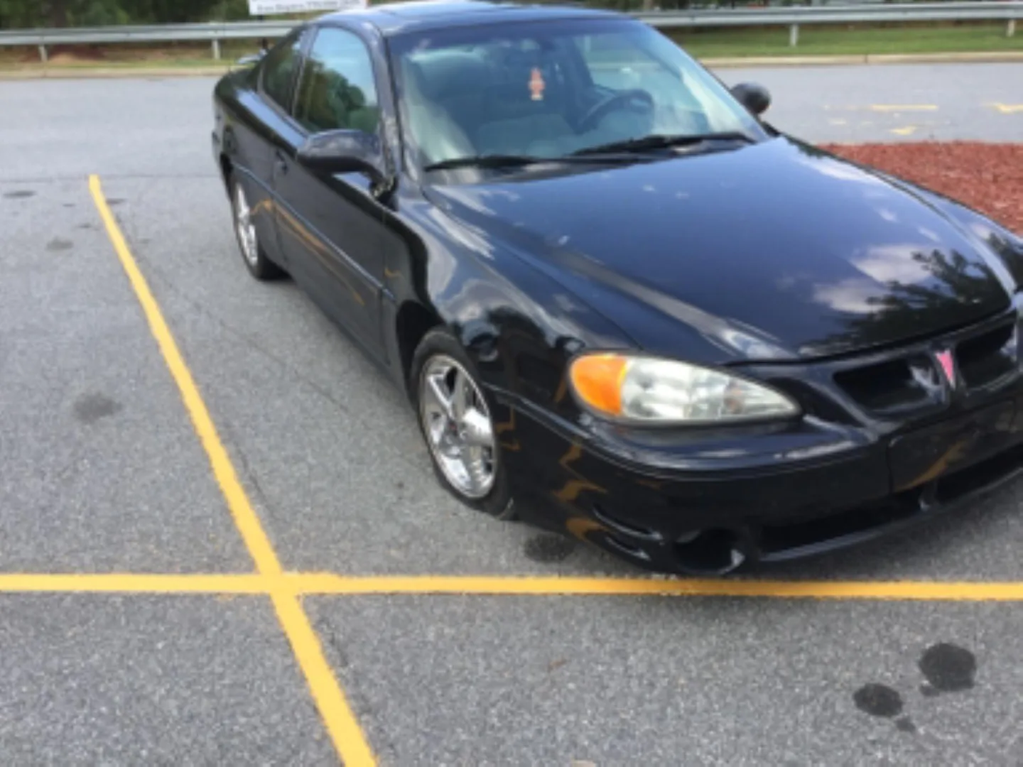 A Roadside Hawks service vehicle assisting a car in a parking lot.
